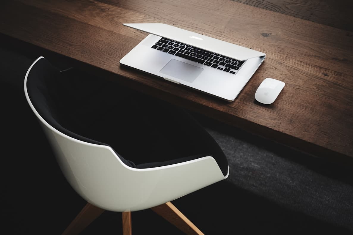 Modern workspace setup with laptop and mouse, representing the creative team behind the QR code generator website
