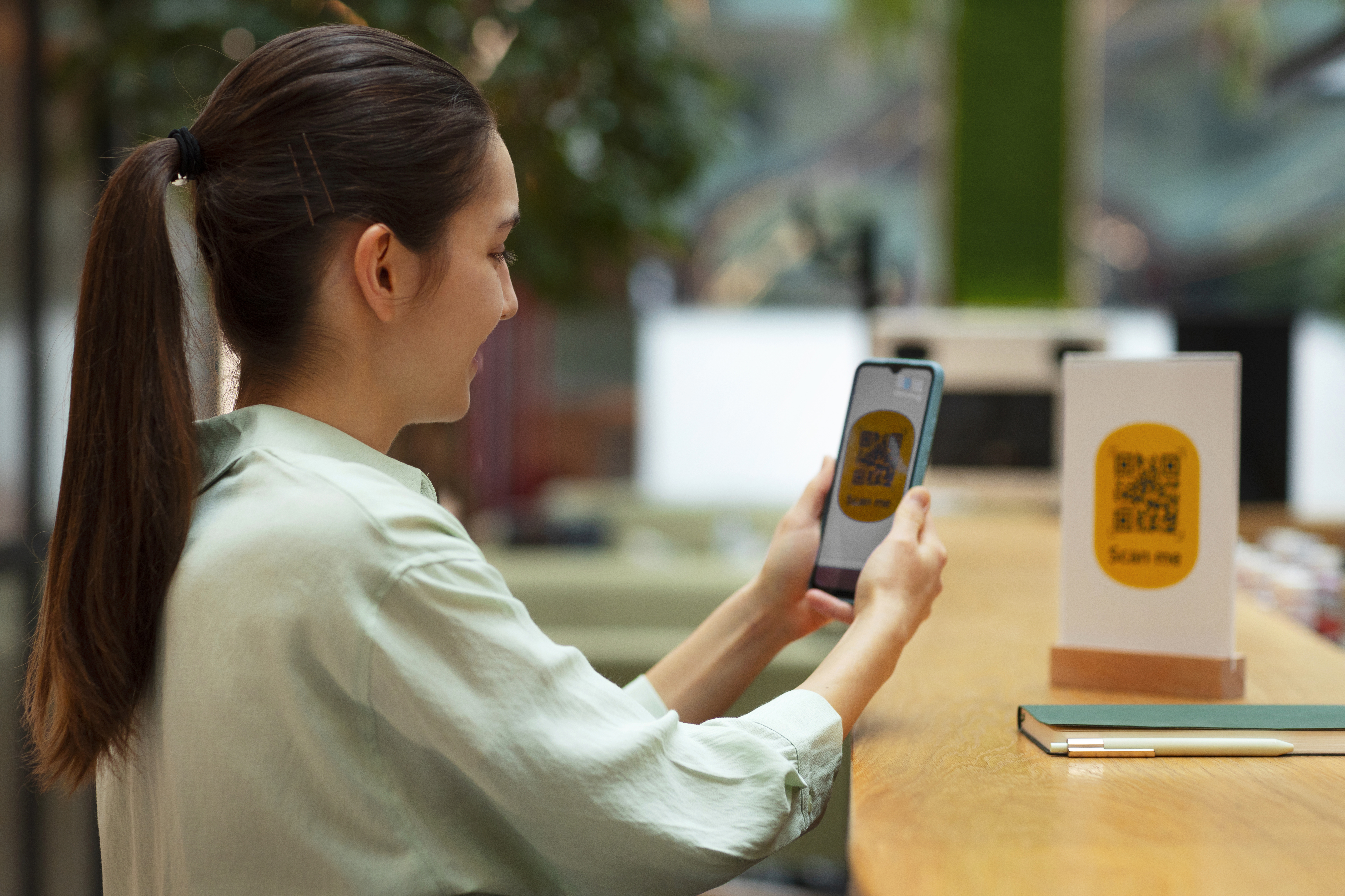 Woman using smartphone for social networking and personal branding with QR code contact sharing system